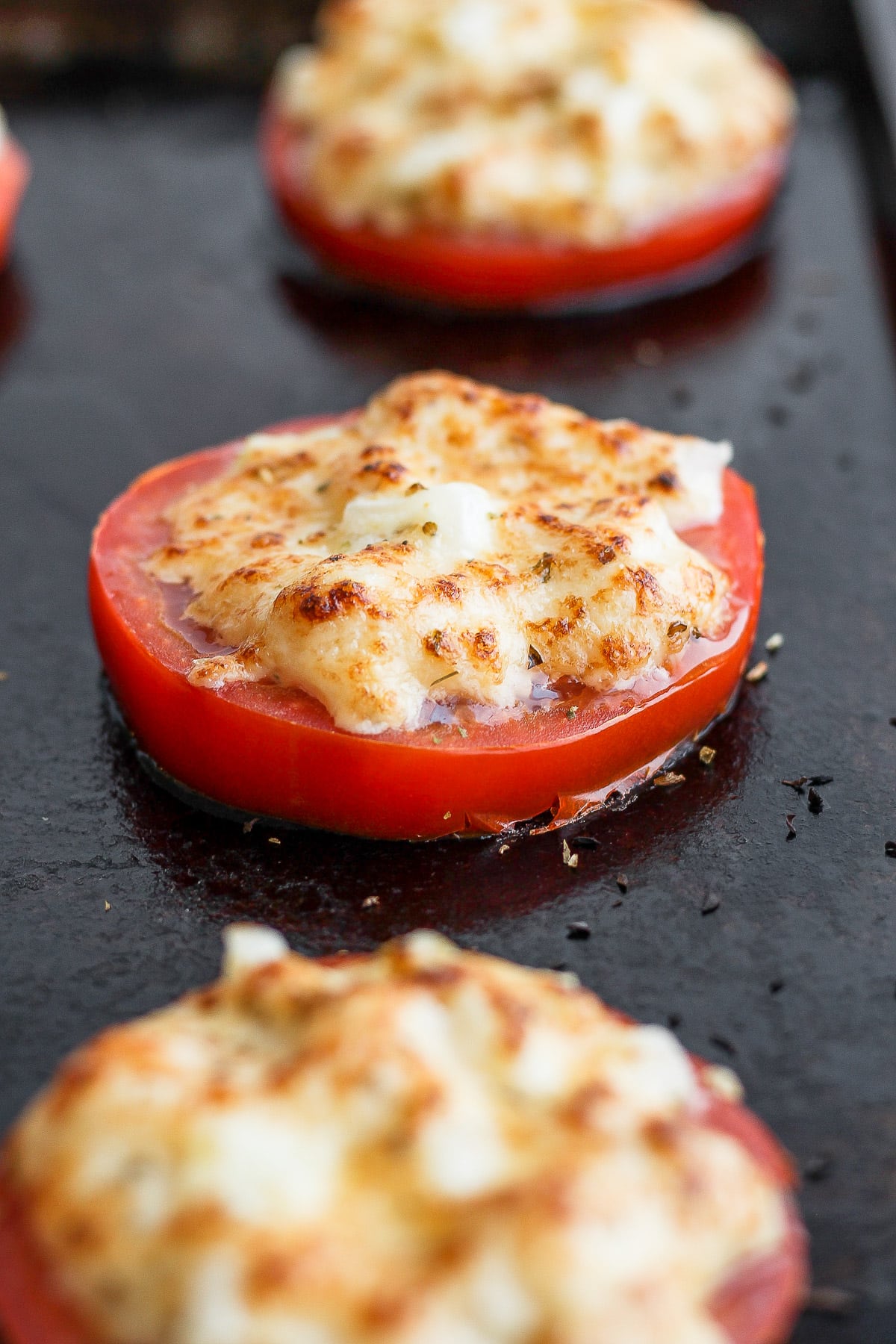 Thick sliced tomatoes with a mayo parmesan mixture on top that is browned from the broiler. 