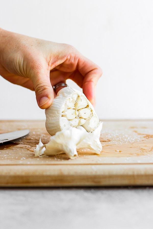 Showing how to cut off an end of a head of garlic. 