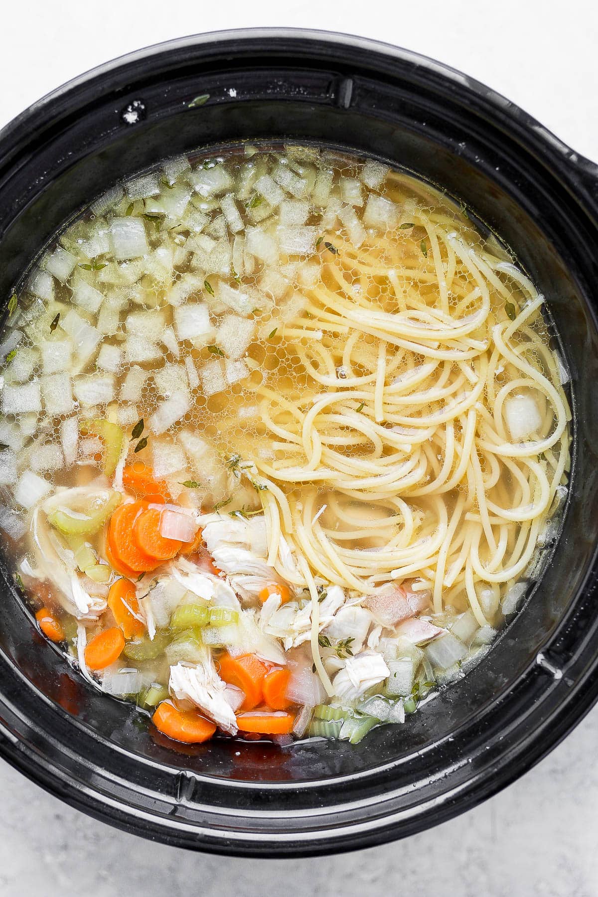 A crockpot full of chicken noodle soup. 