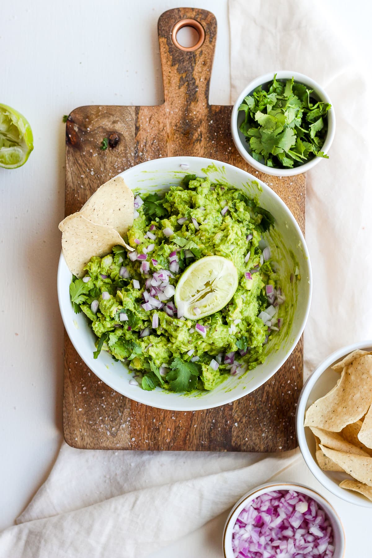 A bowl of guacamole with some tortilla chips.