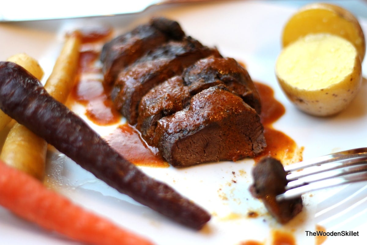 A sliced duck breast with curry sauce on top.