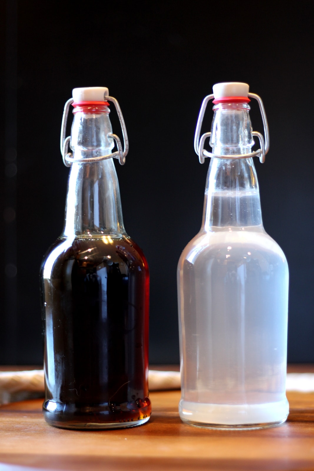 A bottle of maple syrup and a bottle of sap next to each other. 