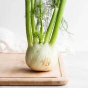 A fennel bulb on a wooden cutting board.