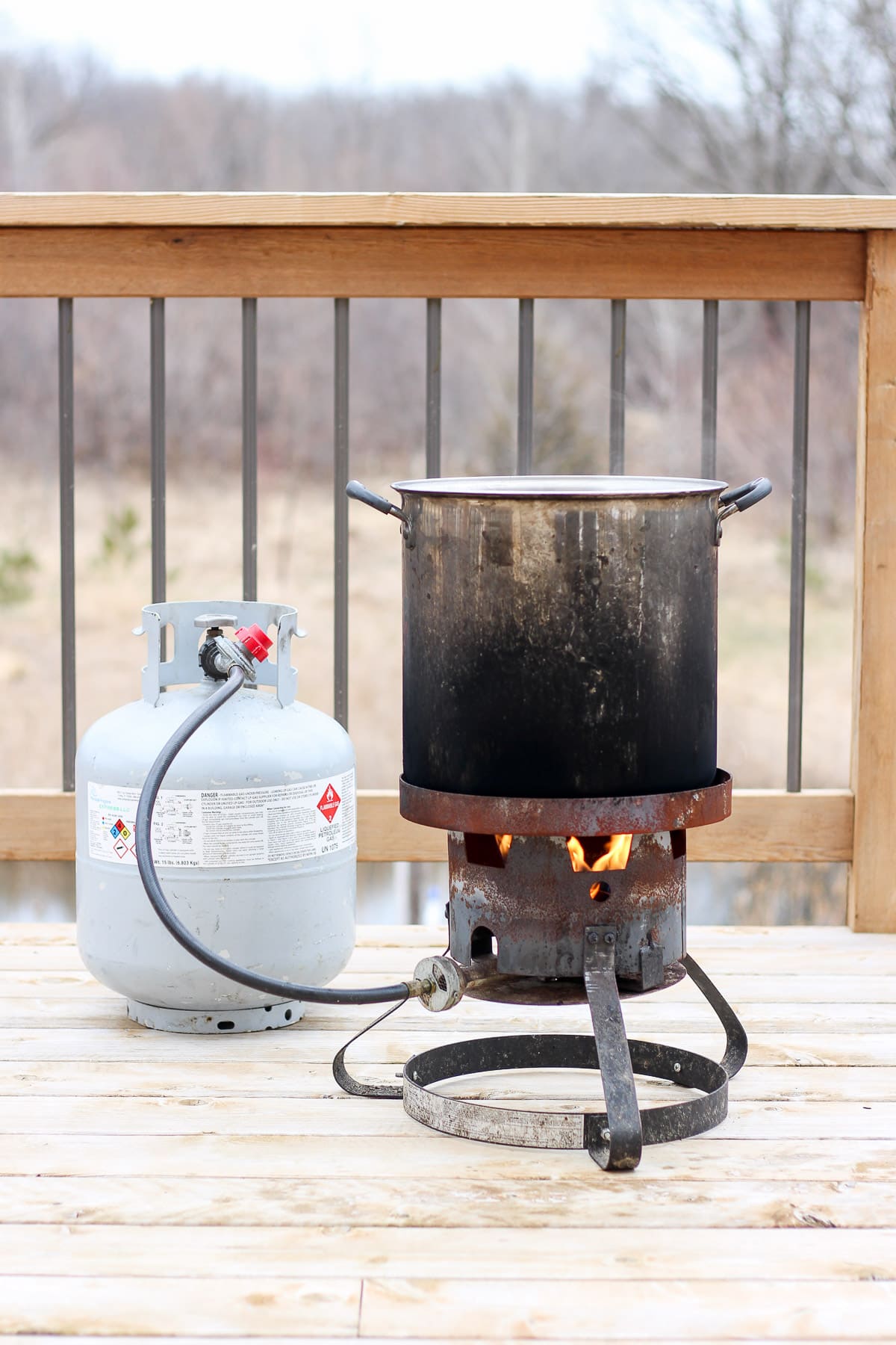 A turkey fryer sitting on a deck. 