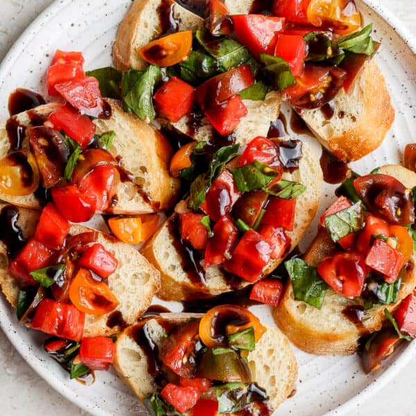 A plate of bruschetta drizzled with balsamic glaze.