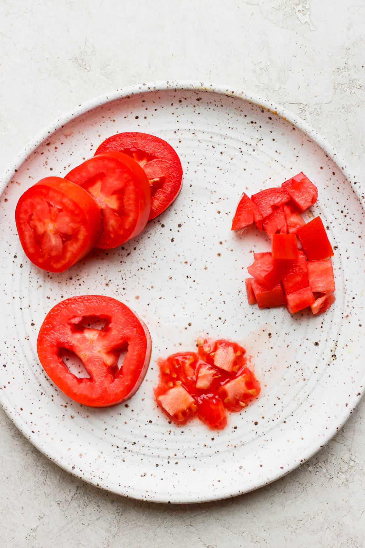 Roma tomatoes sliced and de-seeded on a plate.