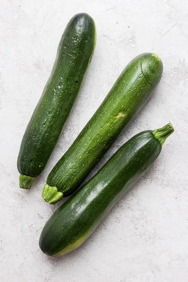 Three small zucchini on the counter.