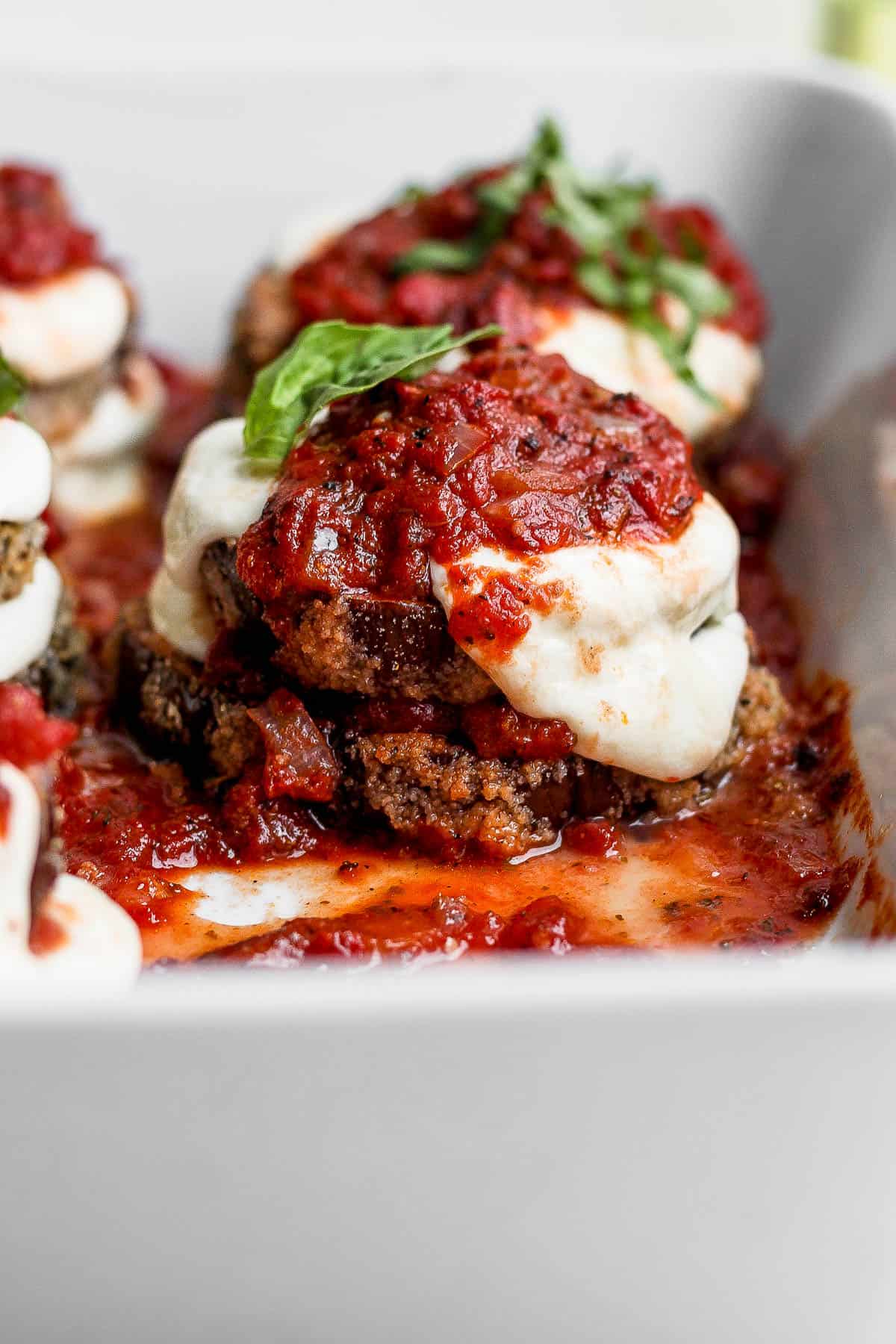 A cooked stack of baked eggplant parmesan in the baking dish.