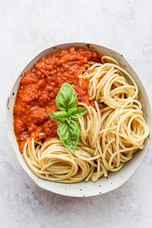 Bowl of spaghetti noodles and marinara sauce. 