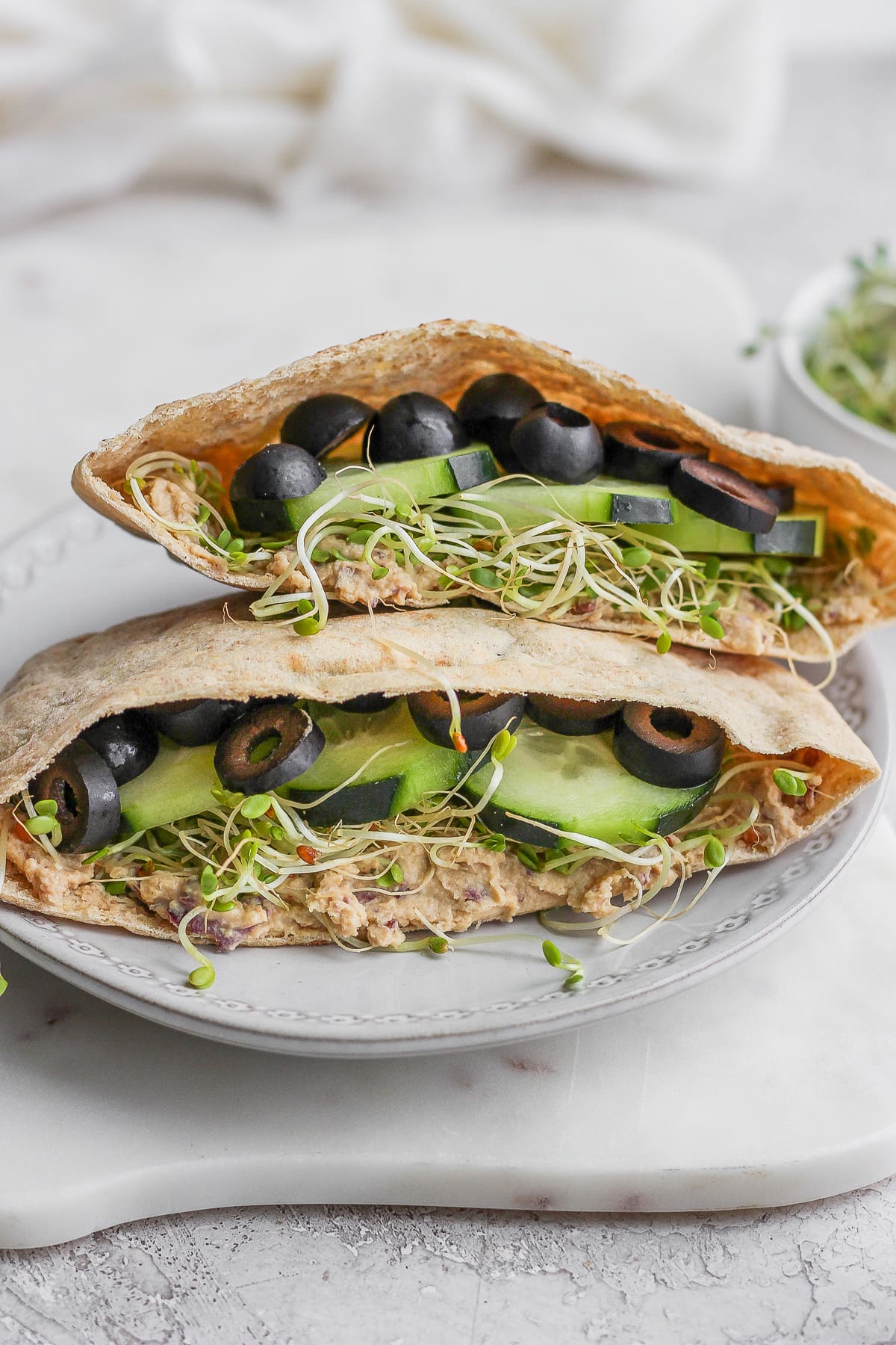 A vegan pita sandwich sitting on a plate. 