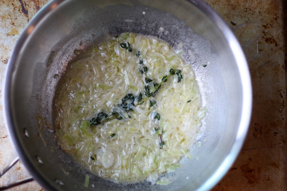 Creamy leek mixture in a metal saucepan.