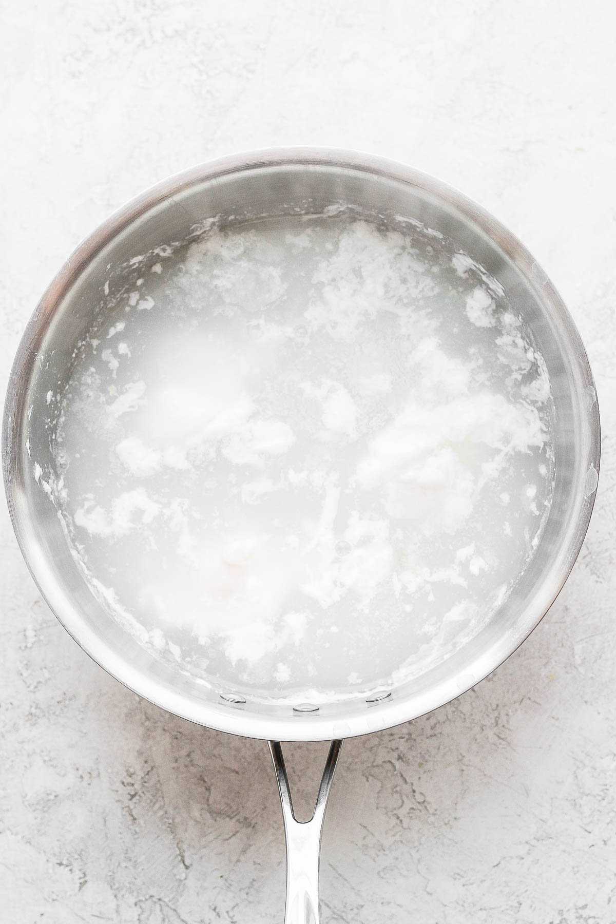 A saucepan full of water and 3 poached eggs. 