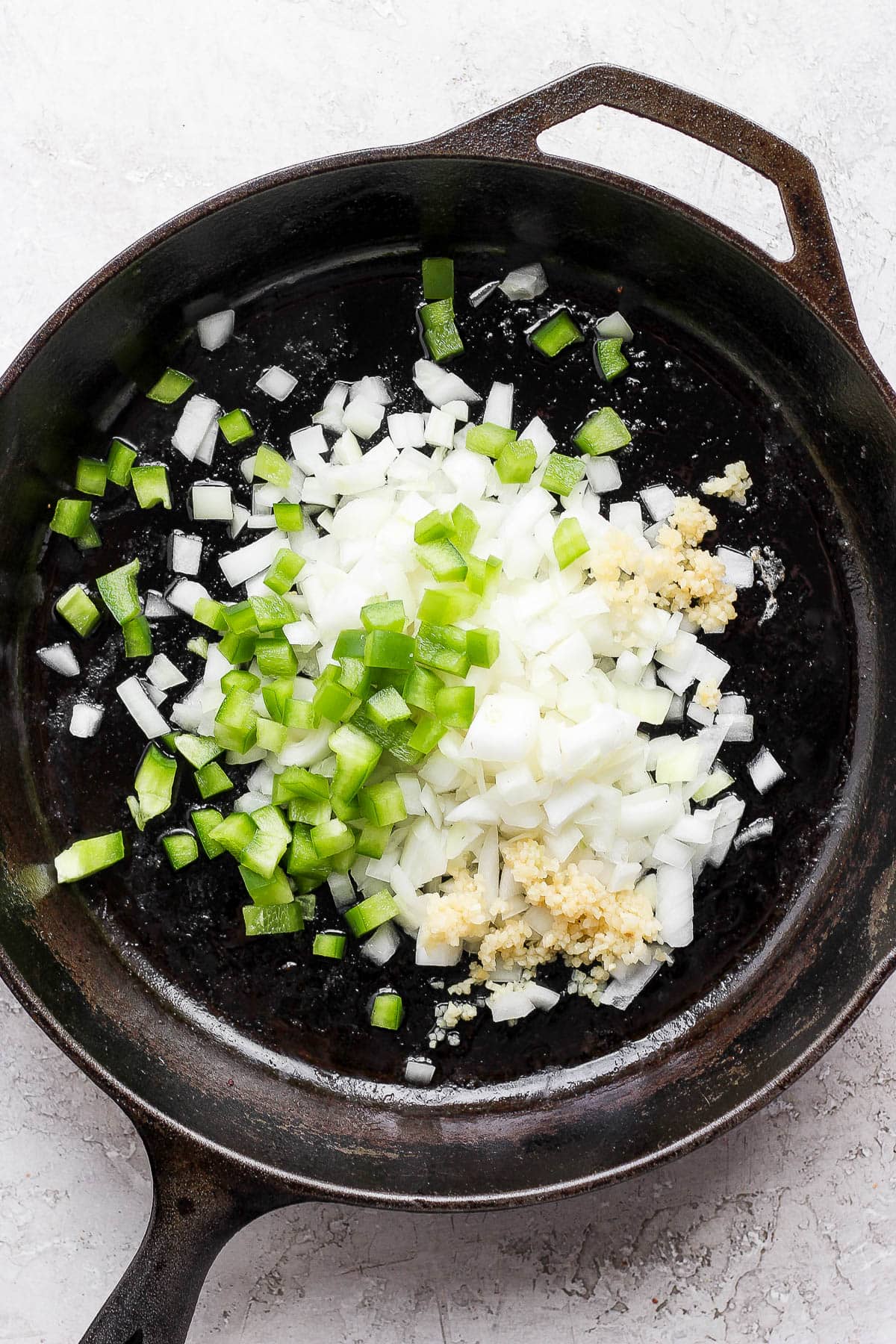 Sauteing onions, garlic and green pepper in a cast iron skillet. 