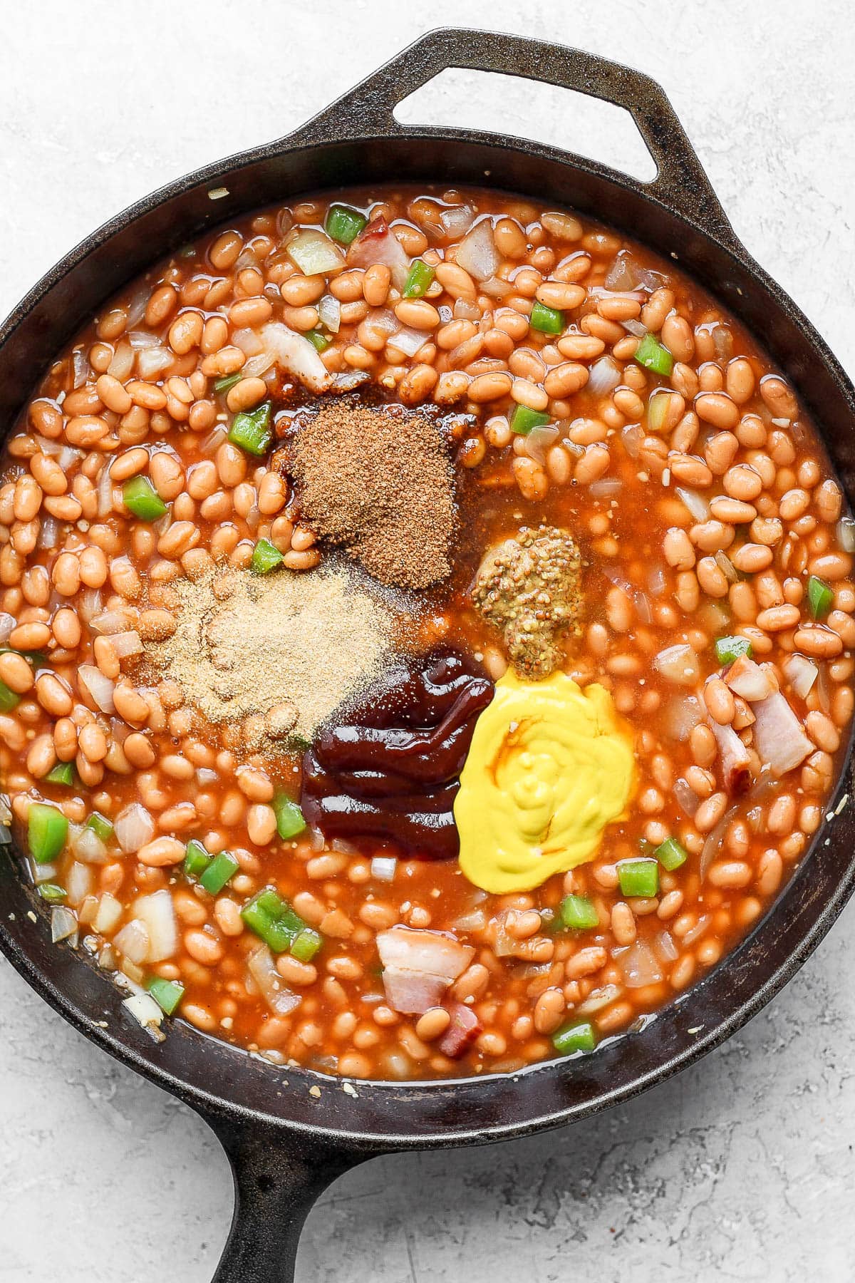 All the ingredients in a cast iron pan to make baked beans. 