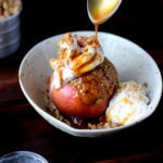 Stuffed Apples + Cardamom Whipped Cream and Vanilla Bean Ice Cream topped with Walnuts and Caramel Sauce. The perfect dessert for fall! thewoodenskillet.com #foodphotography #foodstyling