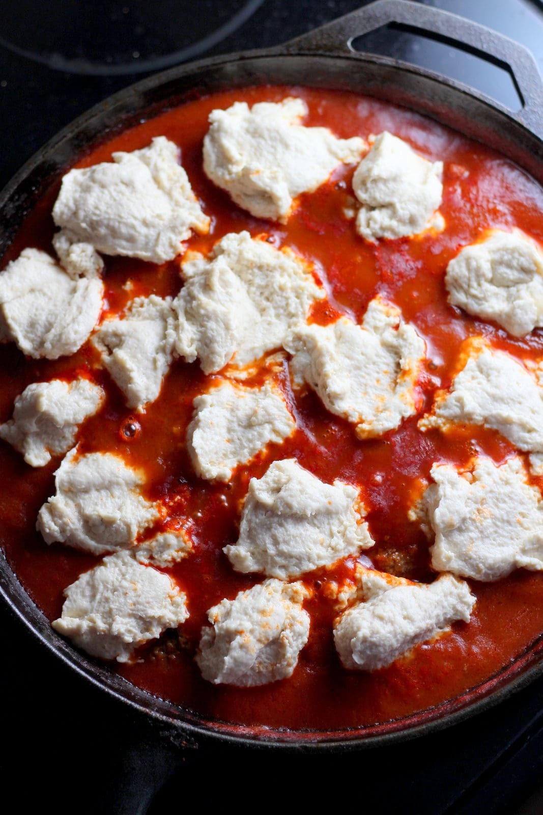 Meatballs and Dumplings - recipe for pillow soft dumplings served with meatballs simmered in tomato sauce. Perfect recipe for a weeknight meal! thewoodenskillet.com 