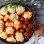 Meatballs and Dumplings - recipe for pillow soft dumplings served with meatballs simmered in tomato sauce. Perfect recipe for a weeknight meal! thewoodenskillet.com #foodphotography #foodstyling