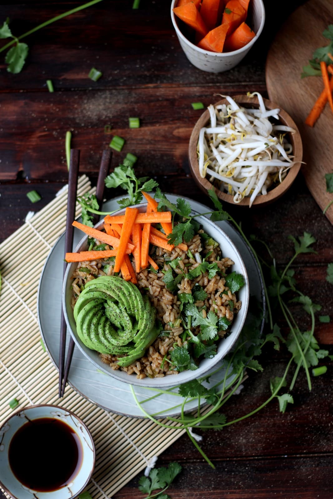 A bowl of cilantro fried rice with avocado and carrots on top.