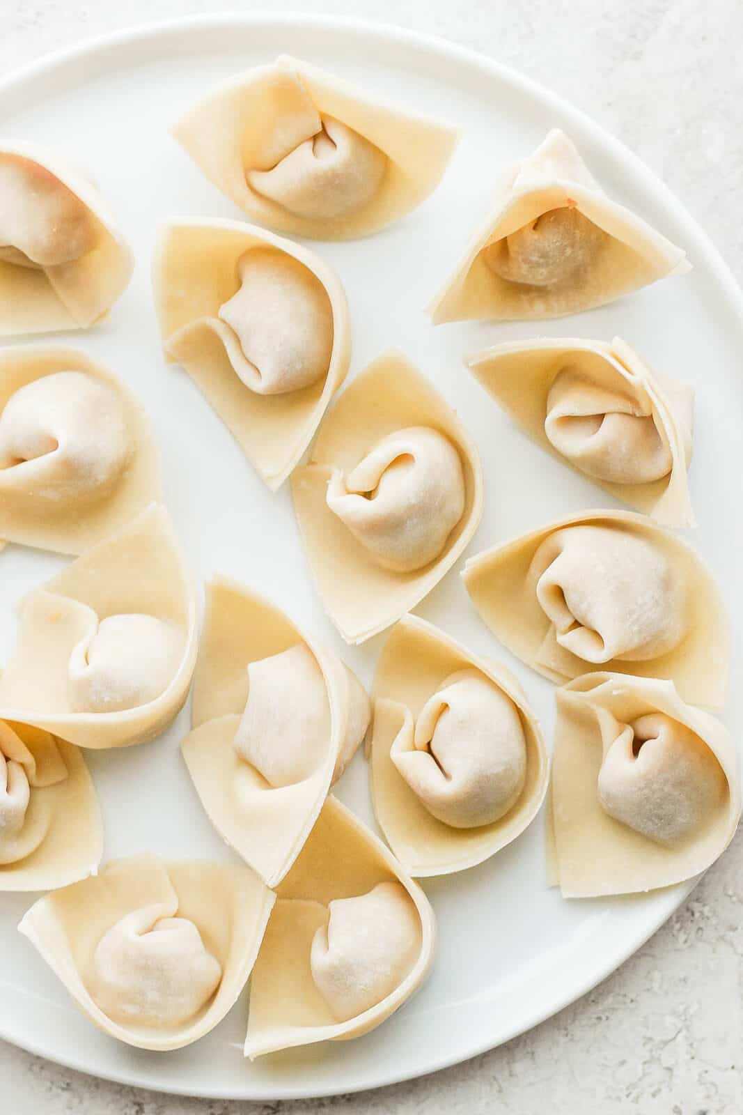A plate of pork wontons before cooking.