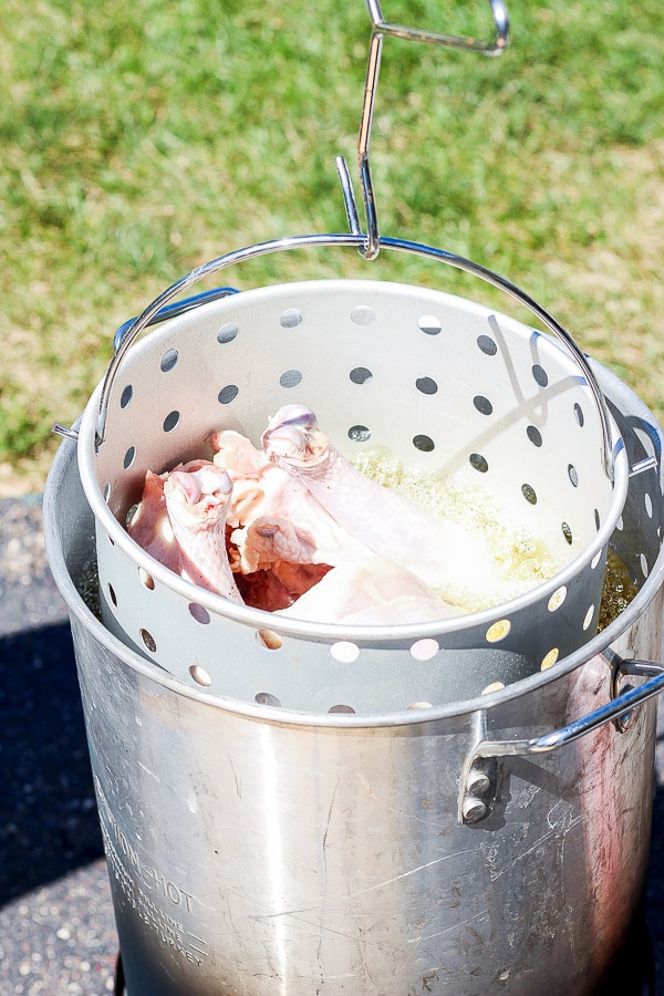 A whole turkey sitting in hot peanut oil being deep fried.