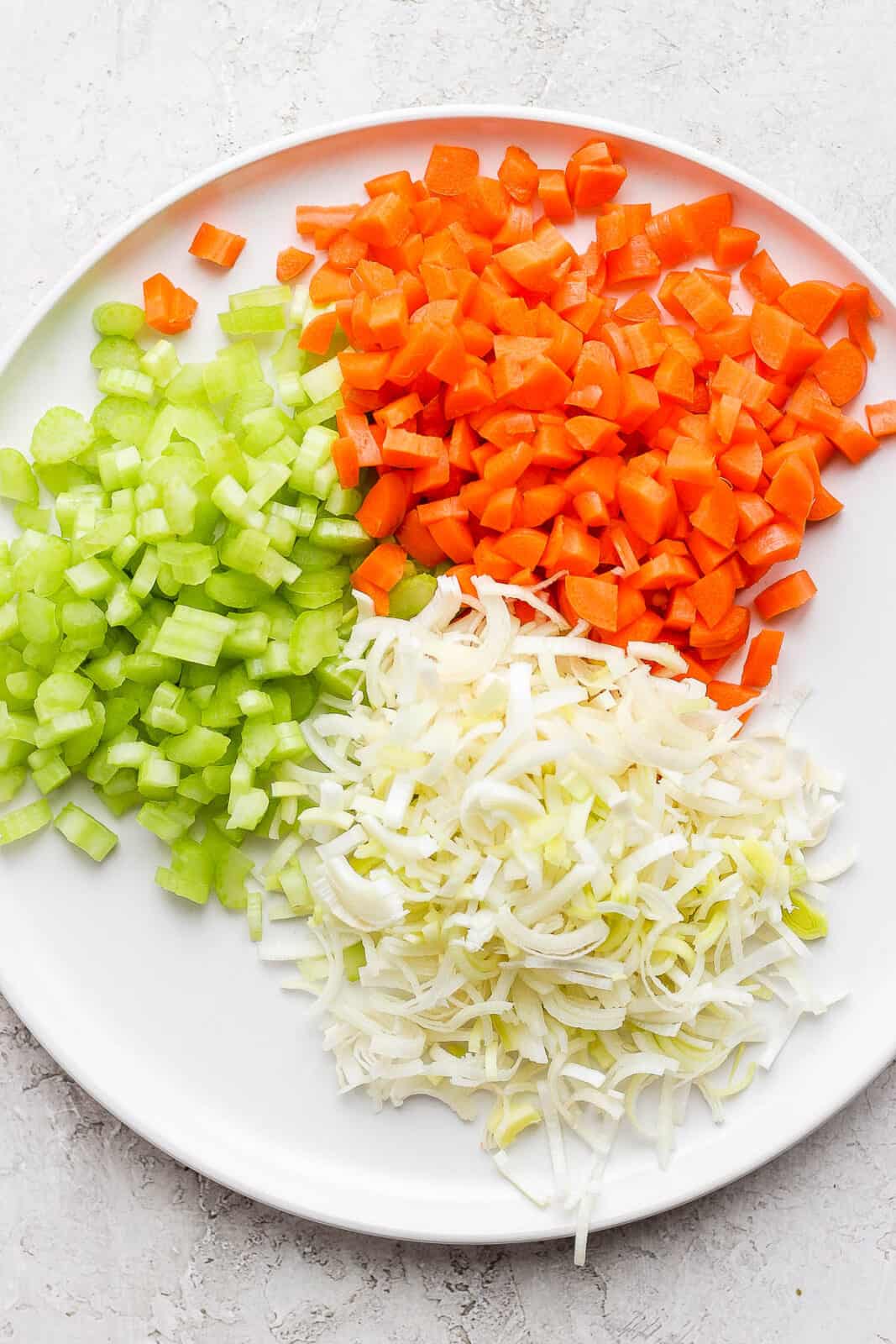 A plate of diced carrots, celery and leeks.