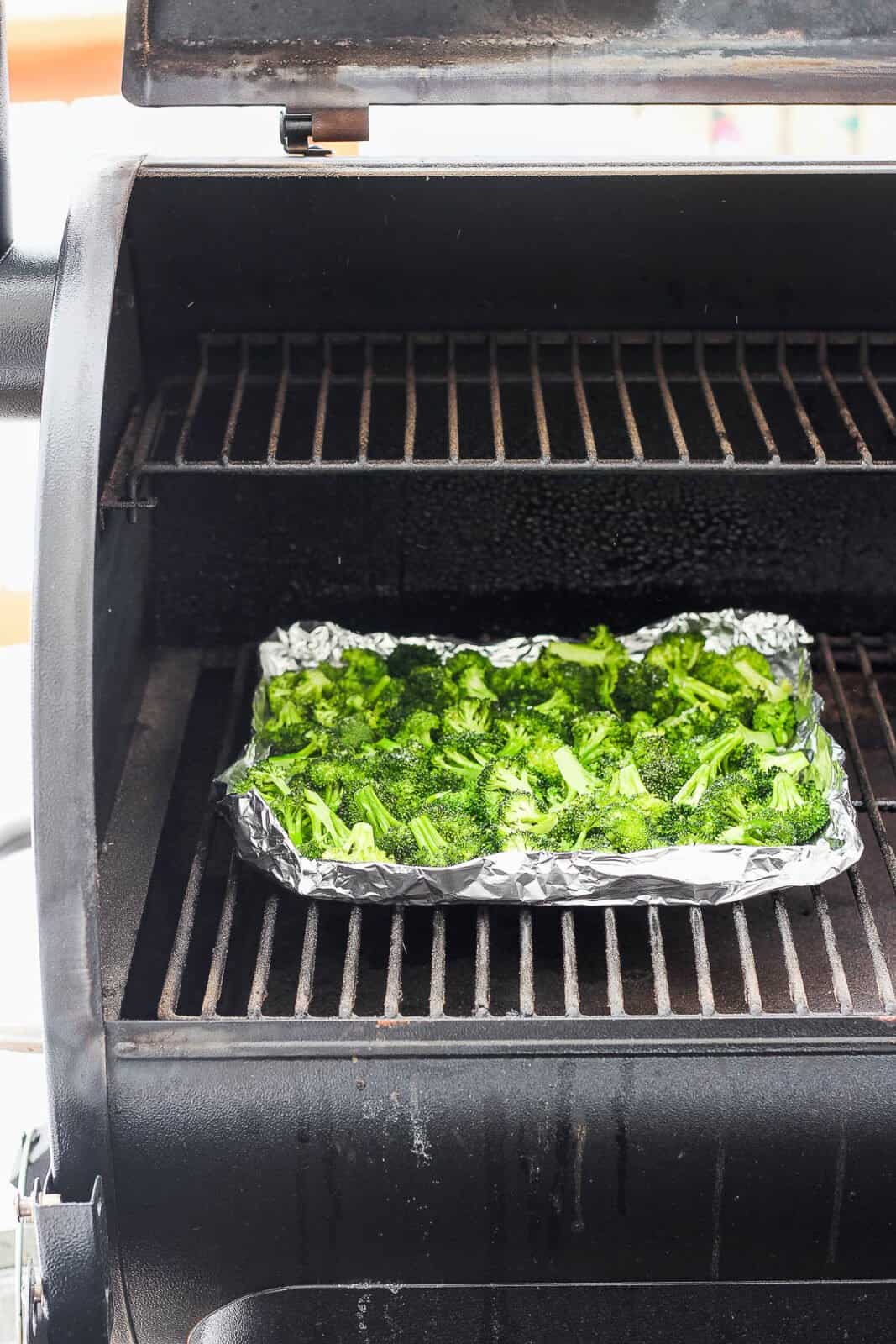Broccoli in an aluminum foil boat on the smoker.