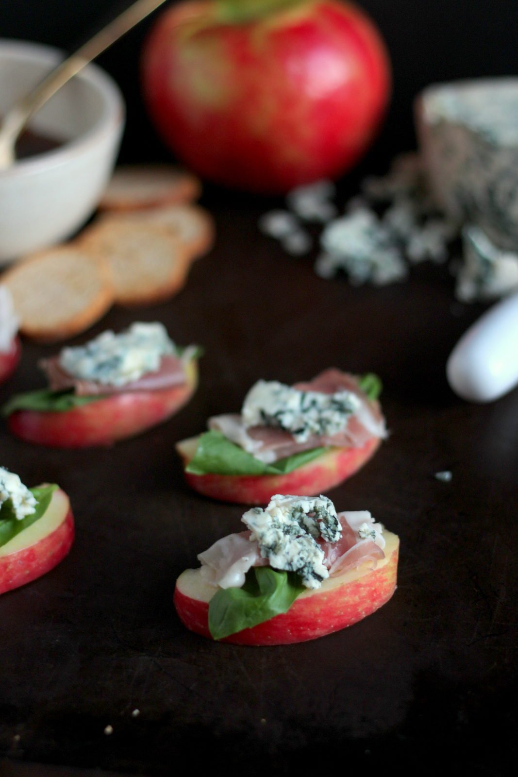Simple Apple Wedge + Basil, Prosciutto and Blue Cheese with Pear-Infused White Balsamic Glaze. A simple and classy appetizer for your next holiday party! thewoodenskillet.com #foodphotography
