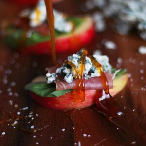 Simple Apple Wedge + Basil, Prosciutto and Blue Cheese with Pear-Infused White Balsamic Glaze. A simple and classy appetizer for your next holiday party! thewoodenskillet.com #foodphotography