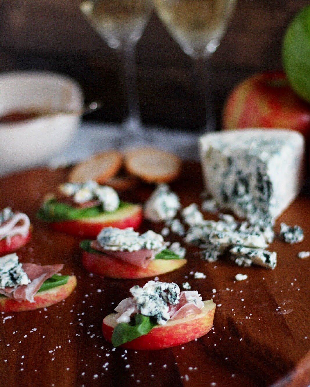 Simple Apple Wedge + Basil, Prosciutto and Blue Cheese with Pear-Infused White Balsamic Glaze. A simple and classy appetizer for your next holiday party! thewoodenskillet.com #foodphotography