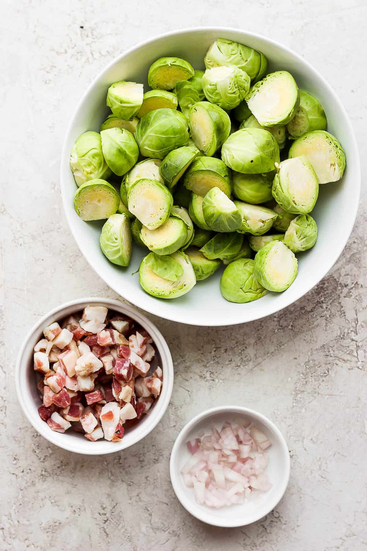 Bowls of brussel sprouts, pancetta and shallots.