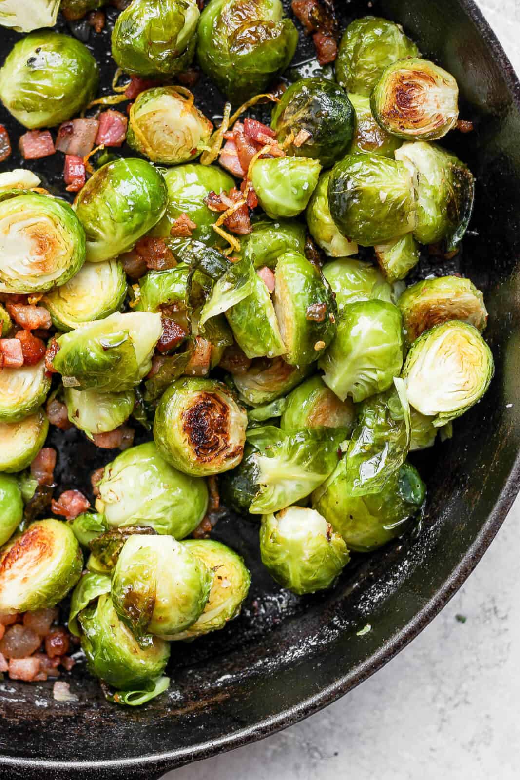 Close up of brussel sprouts in cast iron skillet.