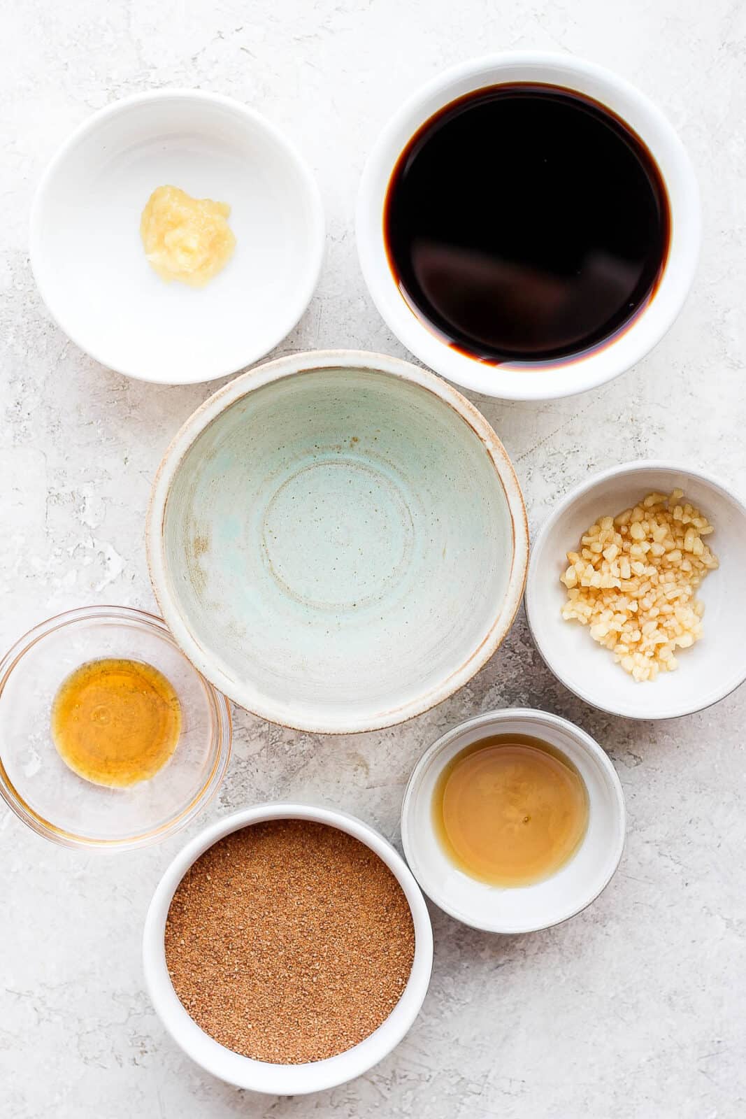 All the ingredients for teriyaki sauce in small bowls.