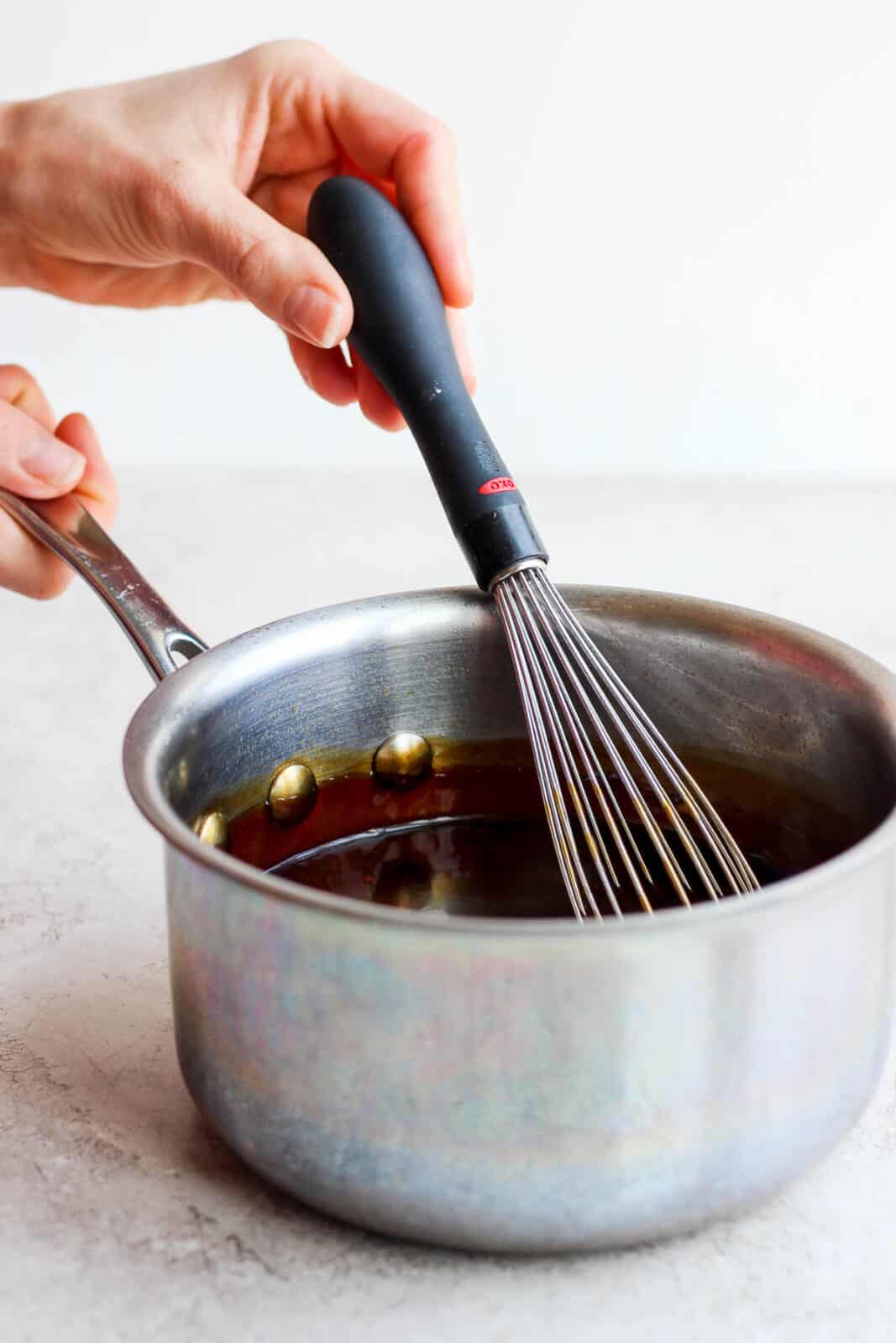 Whisking together ingredients in saucepan as they thicken.