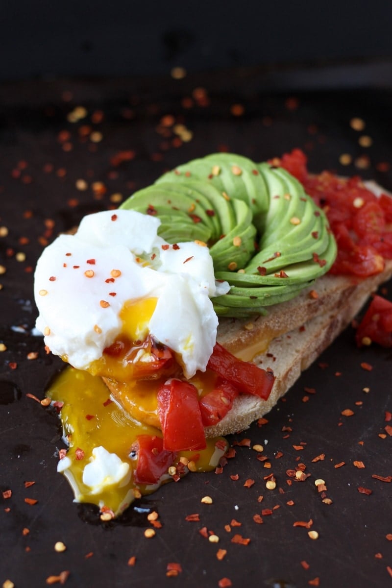 A perfectly runny egg on top of a slice of avocado toast.