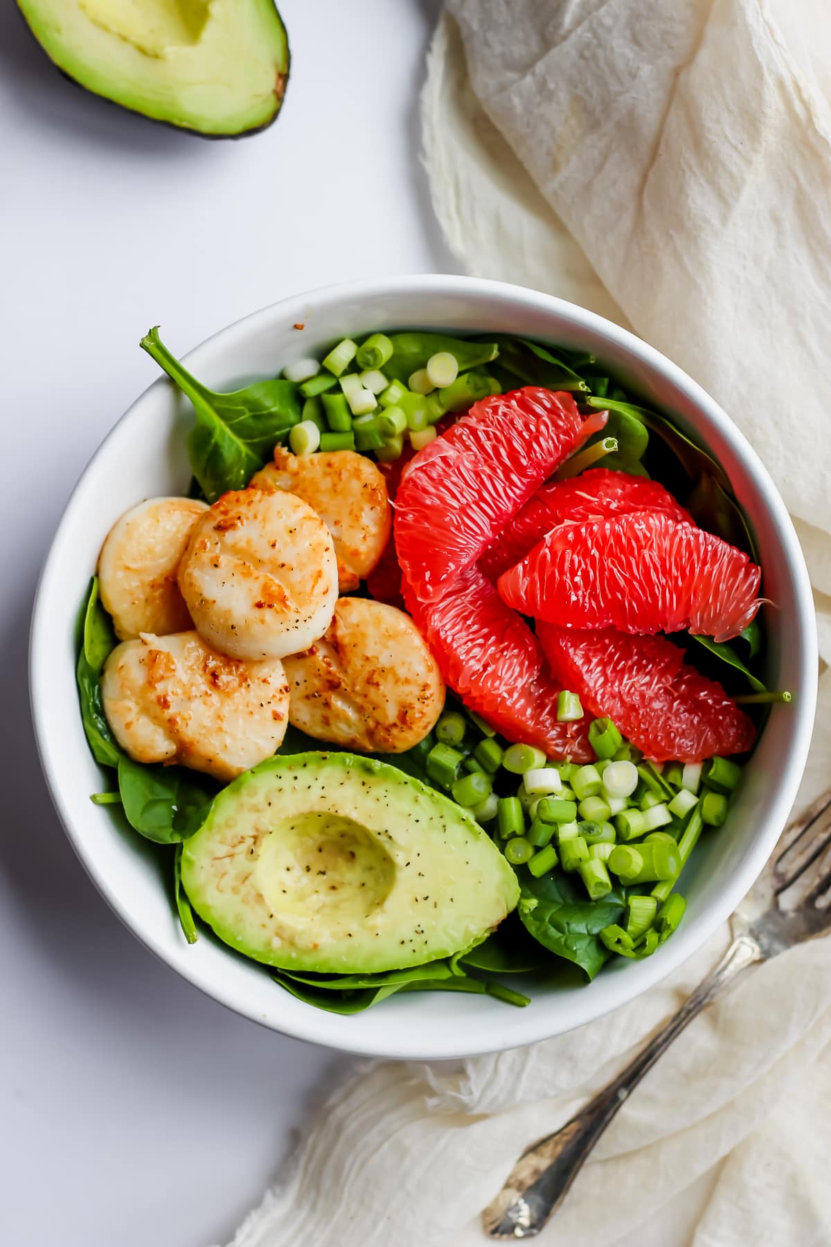 An easy scallop salad in a white bowl.