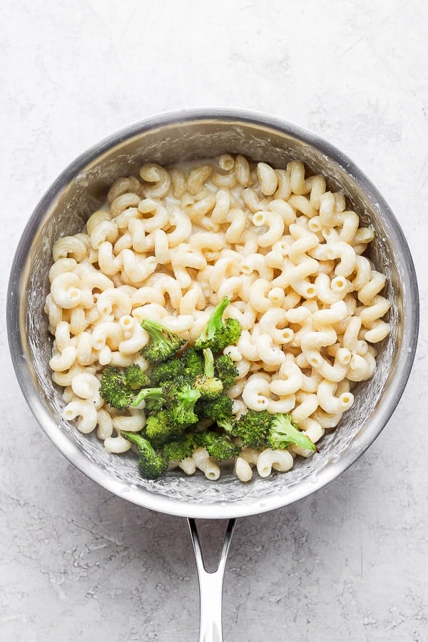 Saucepan with pasta, broccoli and goat cheese sauce inside. 