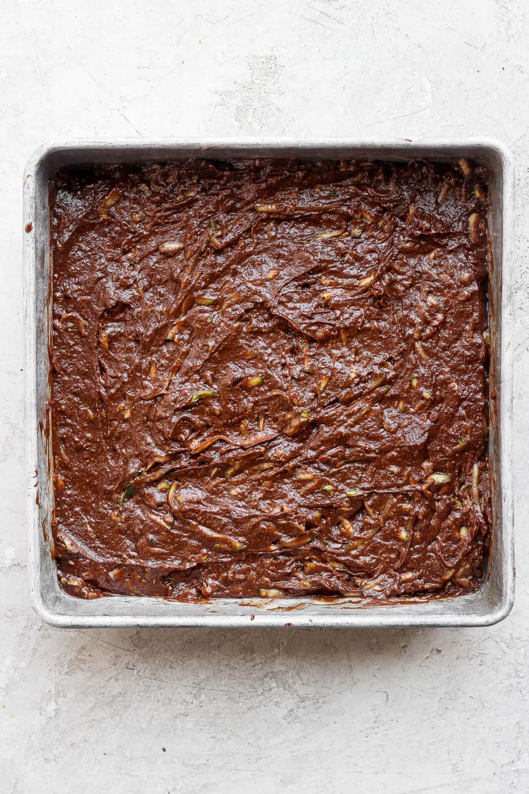 Zucchini Brownies batter in a baking pan. 