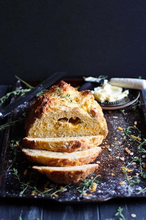 Cheesy Irish Soda Bread + Fresh Thyme and Rosemary. A cheesy twist on the classic Irish tradition - the perfect recipe for St. Patrick's Day! thewoodenskillet.com #stpatricksday #irishsodabread The best homemade Irish soda bread.