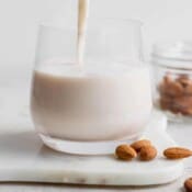Almond milk being poured into a glass.