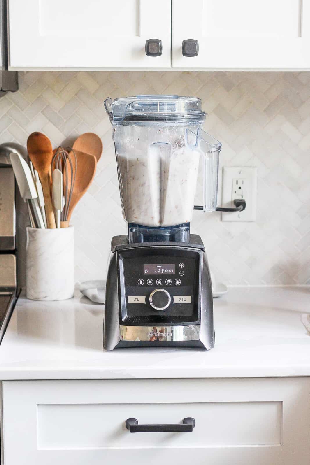 A high speed blender with almonds and water inside. 