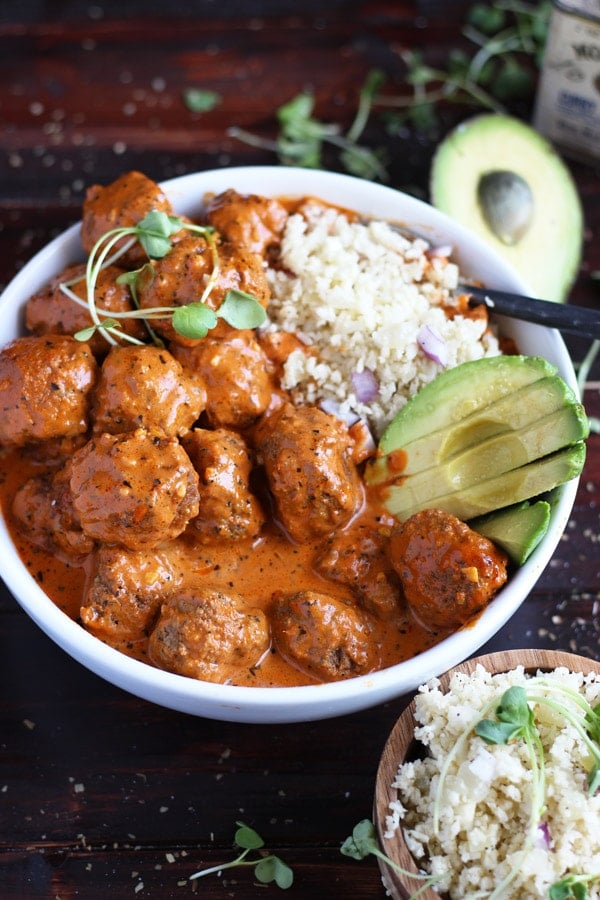 A cauliflower rice bowl with curried meatballs and avocado.