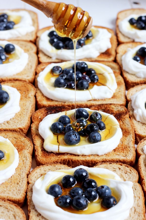 Yogurt toast with honey being drizzled on top.