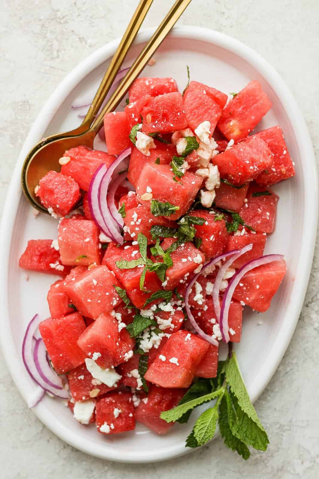 A platter full of watermelon feta salad with mint and red onions. 