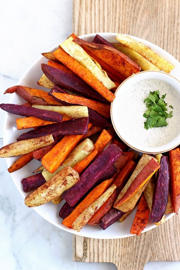 Sweet potato sticks on a platter with a small dish of ranch dressing.