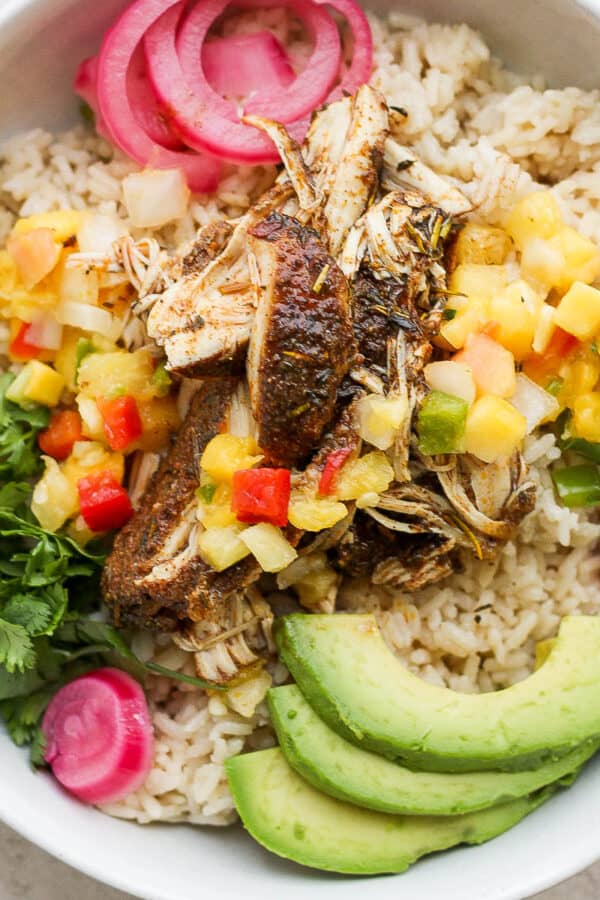 Bowl of crock pot jerk chicken with rice and avocado.