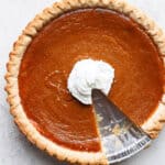 Dairy-Free Pumpkin Pie in a pie plate with one slice taken out.