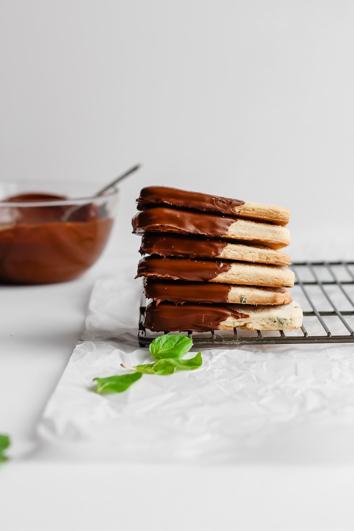 A stack of mint chocolate vegan shortbread cookies on a wire rack.