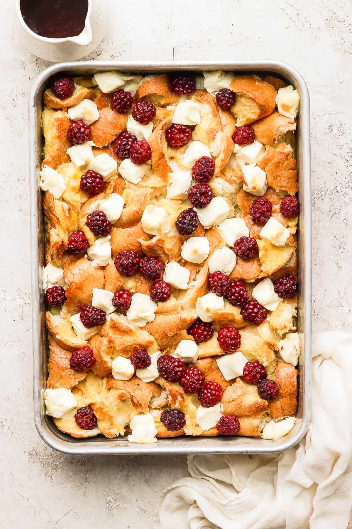 A cooked french toast bake with cream cheese and blackberries on top.