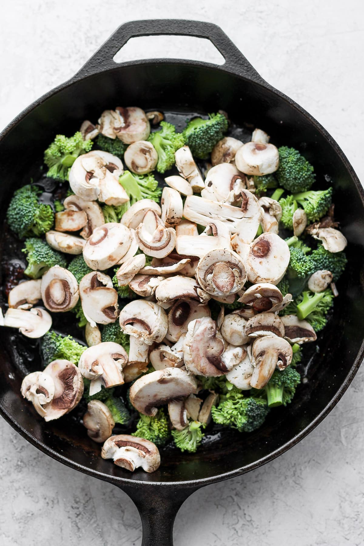 Cast iron skillet with broccoli and mushrooms. 