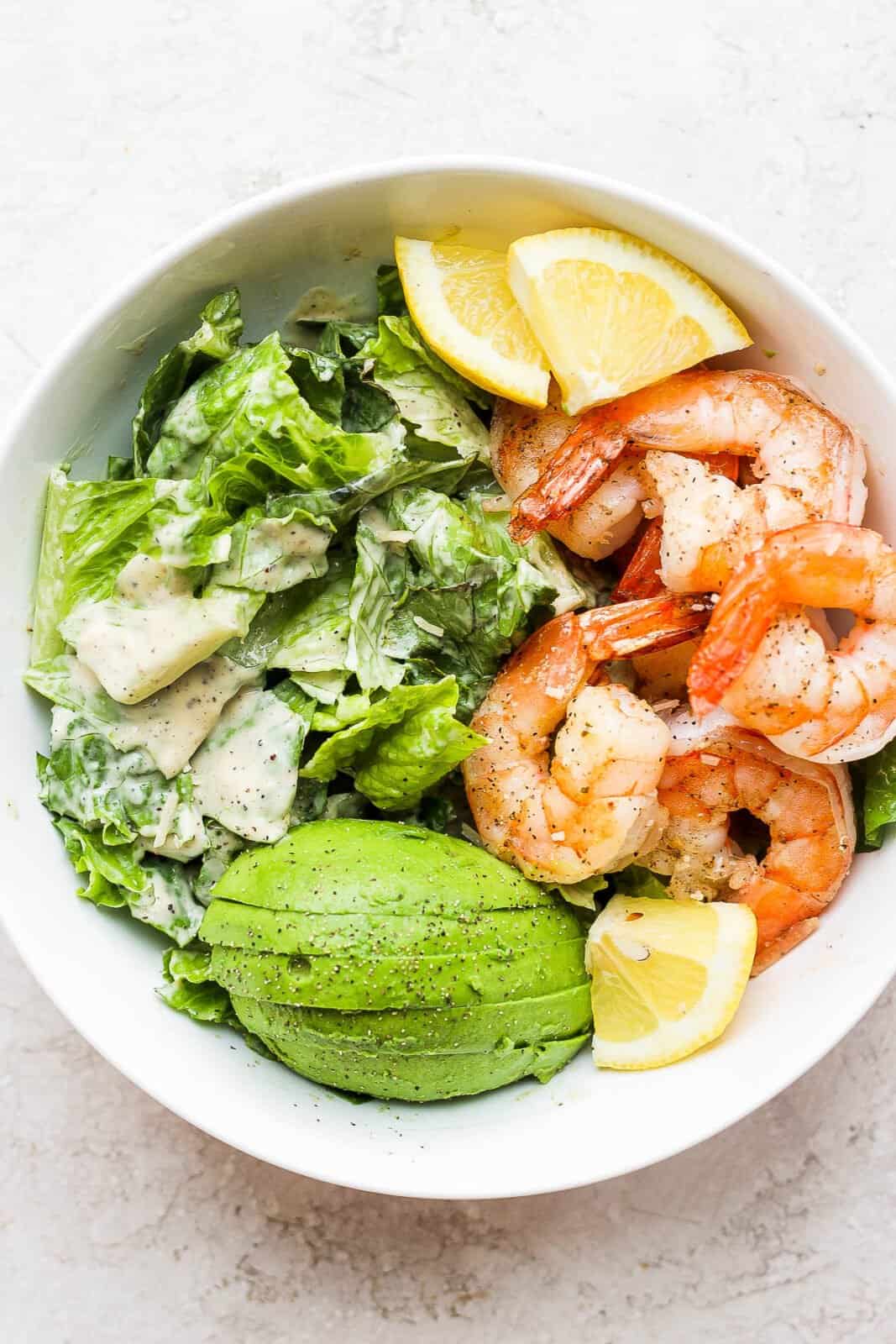 A bowl of shrimp caesar salad without dairy. 